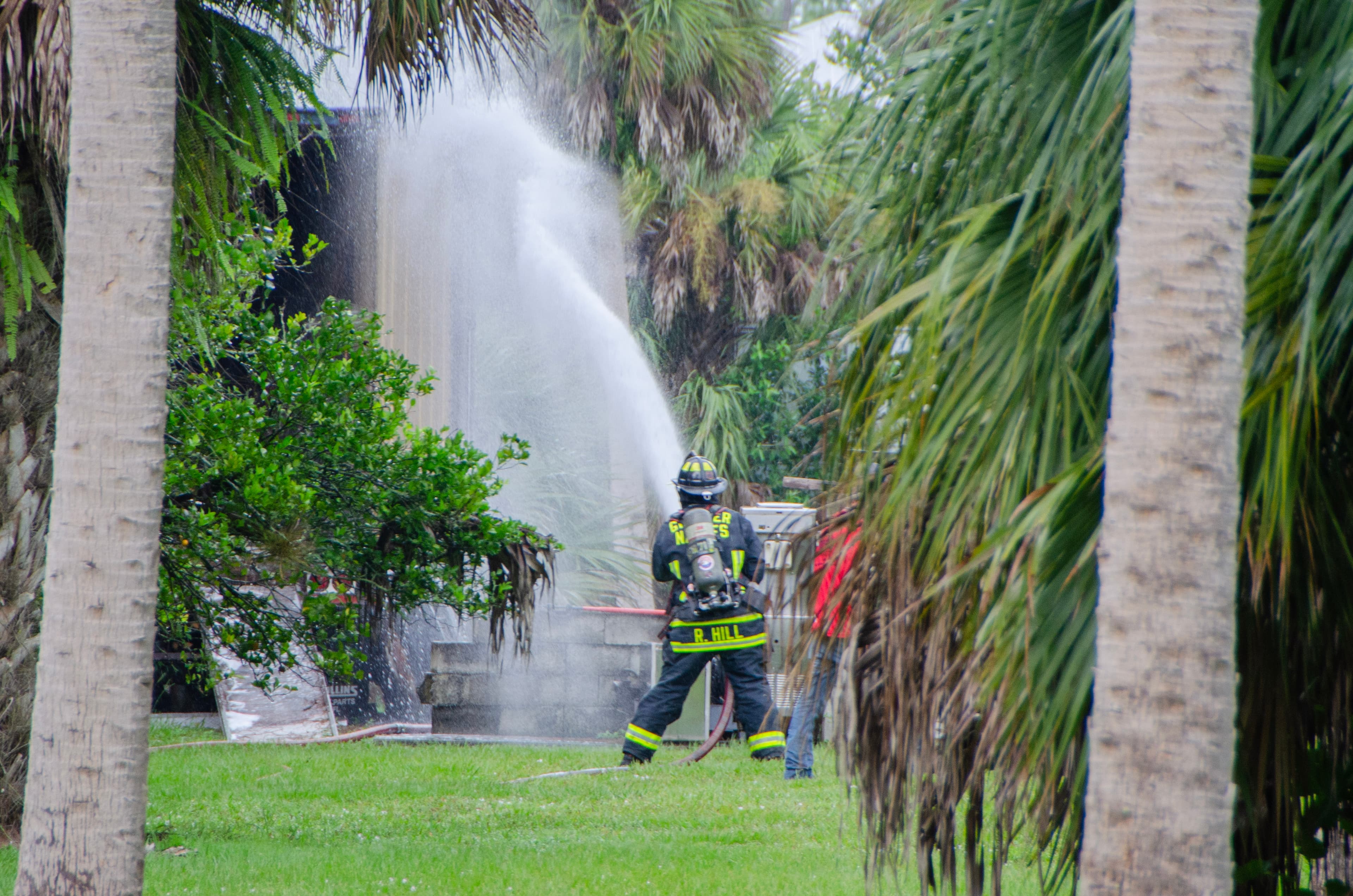 Firefighters extinguish small trailer and brush fire